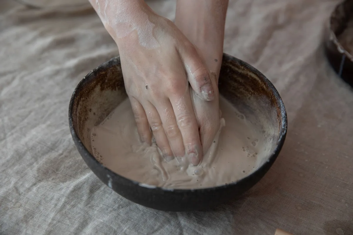 Préparation d'une pâte d'argile dans un récipient en plastique avec une spatule non métallique