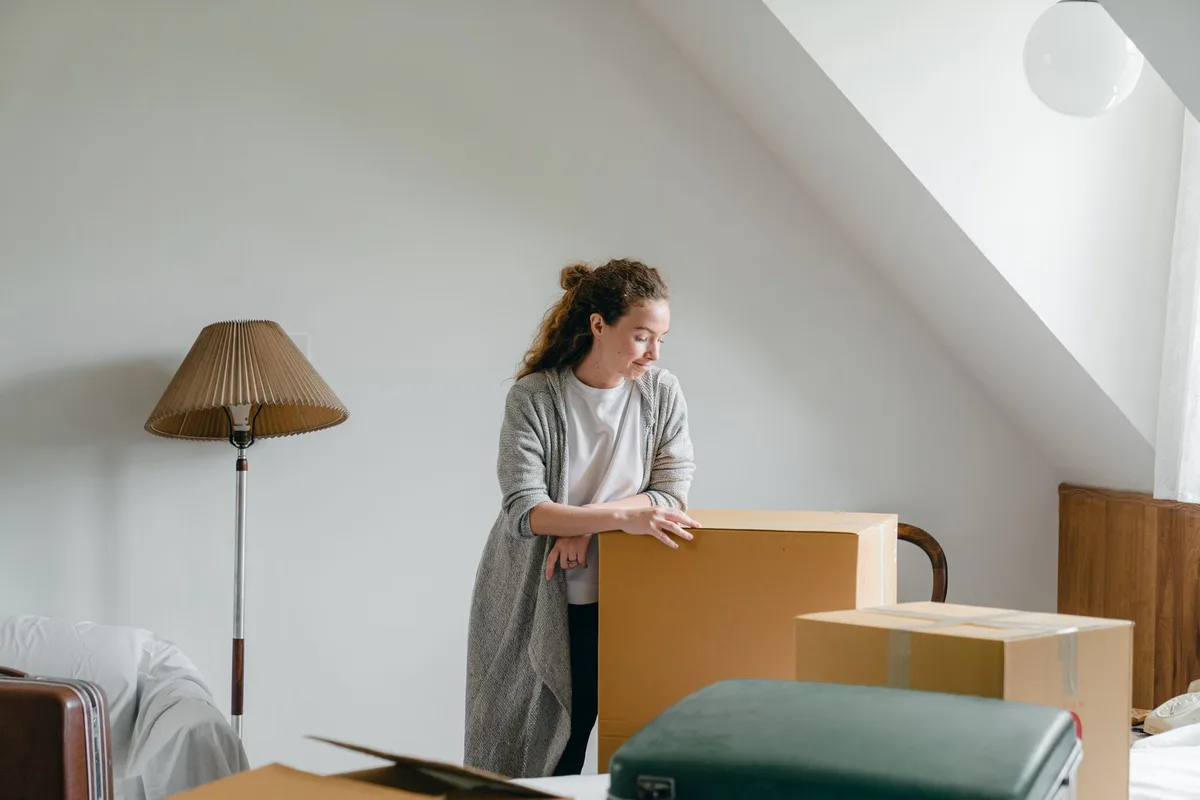Coin sombre d'un grenier encombré de cartons, isolation et débris—habitat idéal pour les nids de rongeurs.