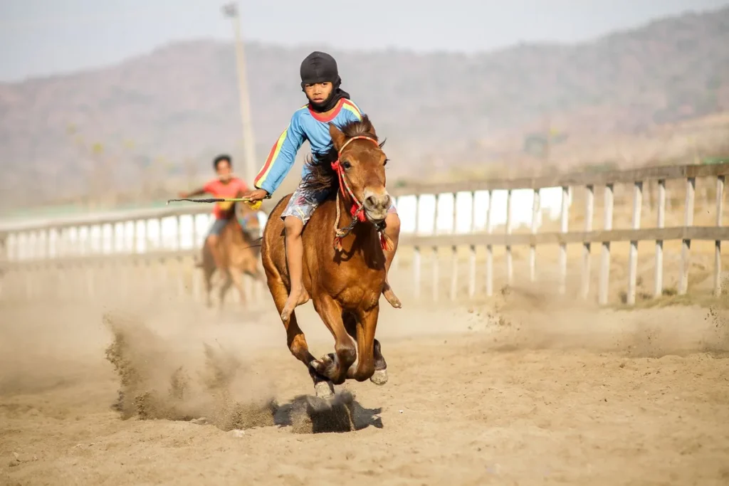 Jeunes pratiquants en tenue colorée exécutant des mouvements coordonnés avec des chevaux-bâtons lors d'une compétition