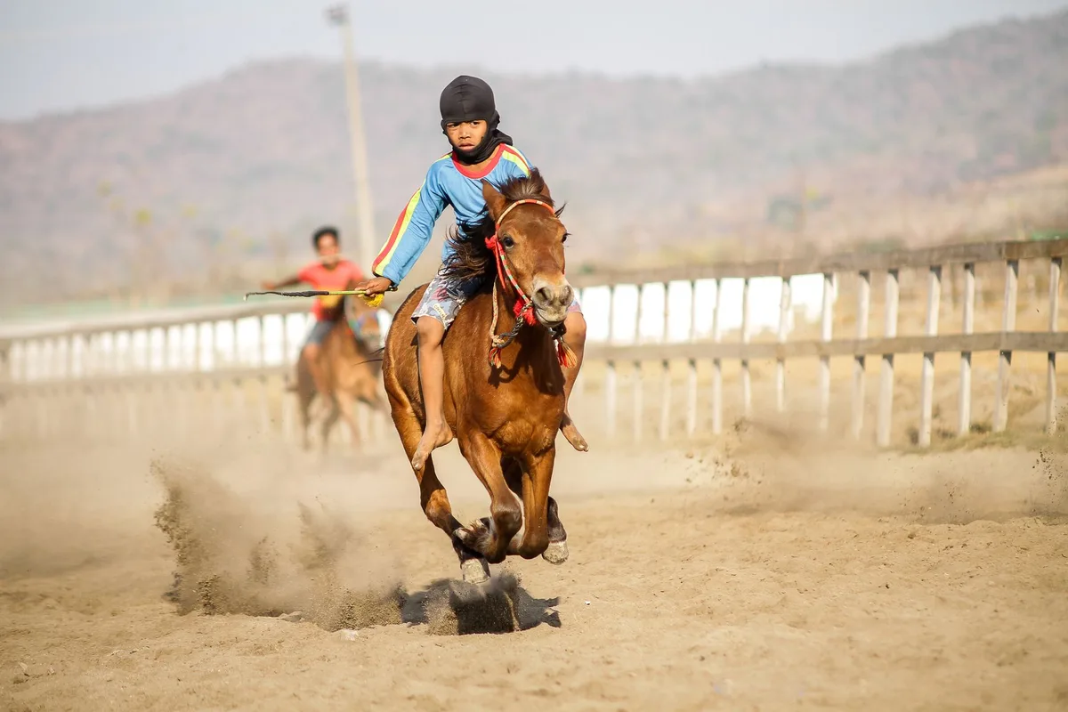Jeunes pratiquants en tenue colorée exécutant des mouvements coordonnés avec des chevaux-bâtons lors d'une compétition
