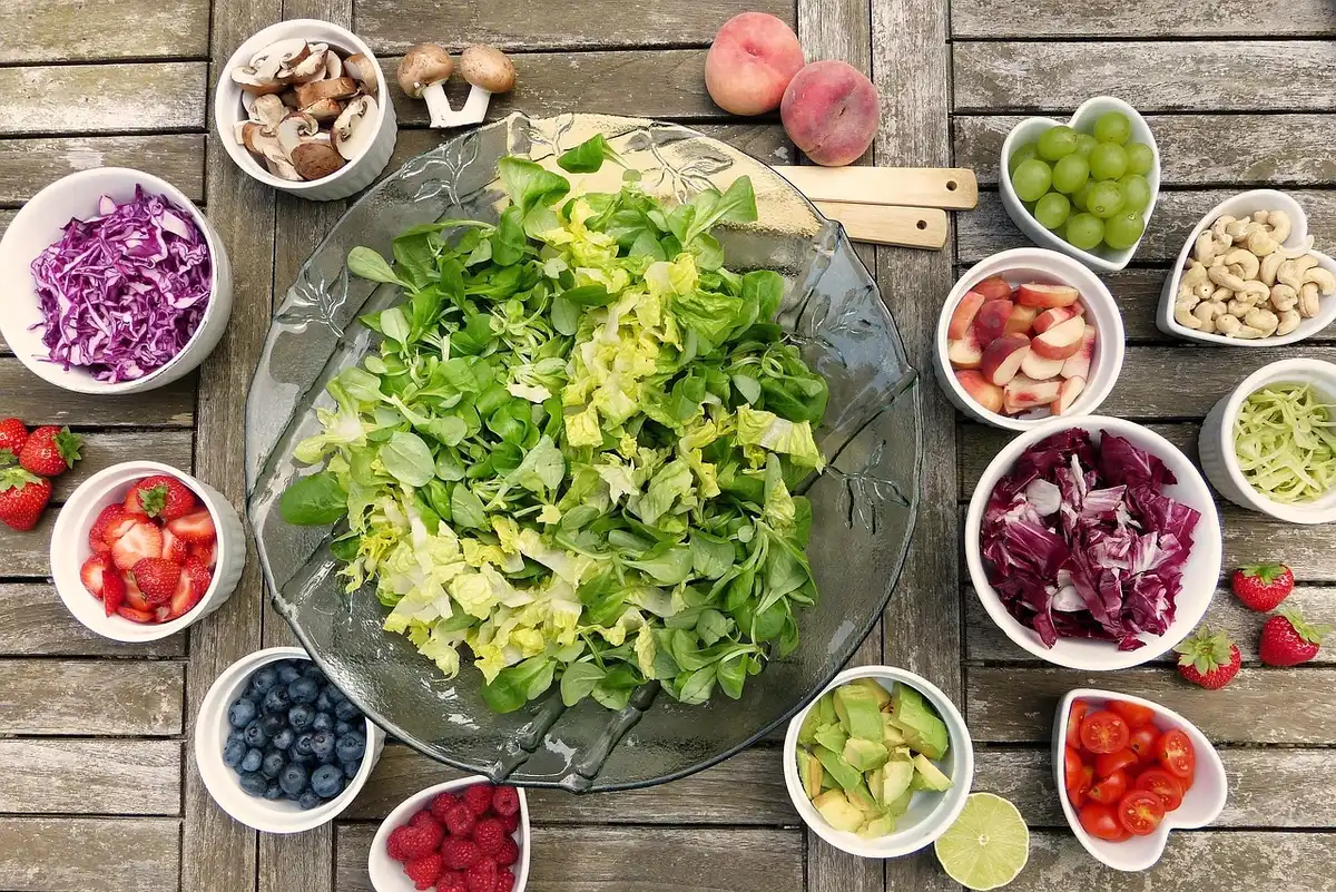Assortiment de granulés, fruits et légumes pour perroquet illustrant un régime équilibré
