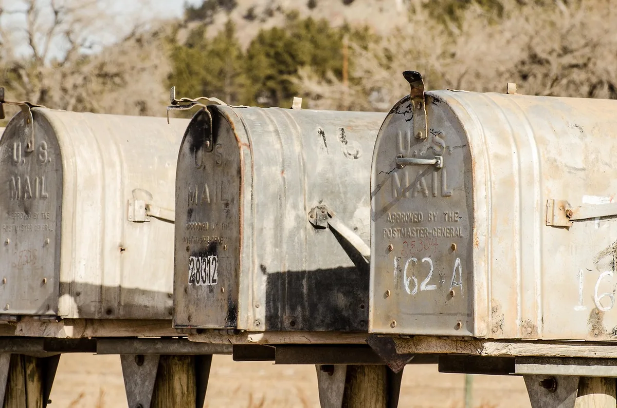 Main rangeant une étagère et une boîte à courrier