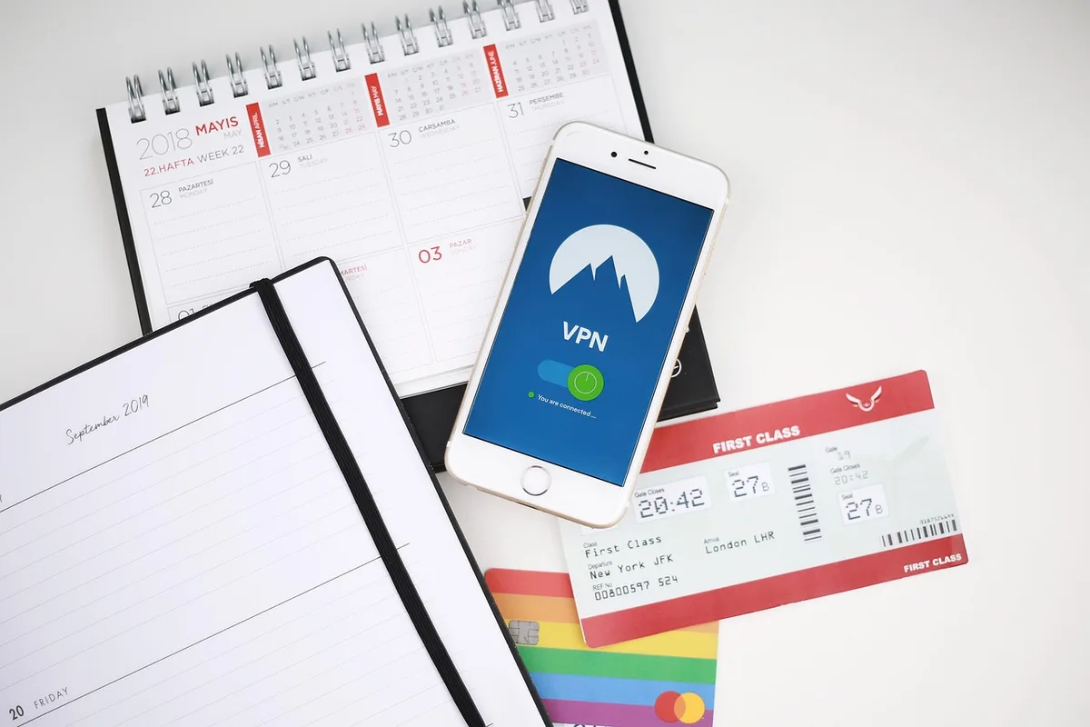 Personne prenant des notes avec un calendrier et une tasse de café