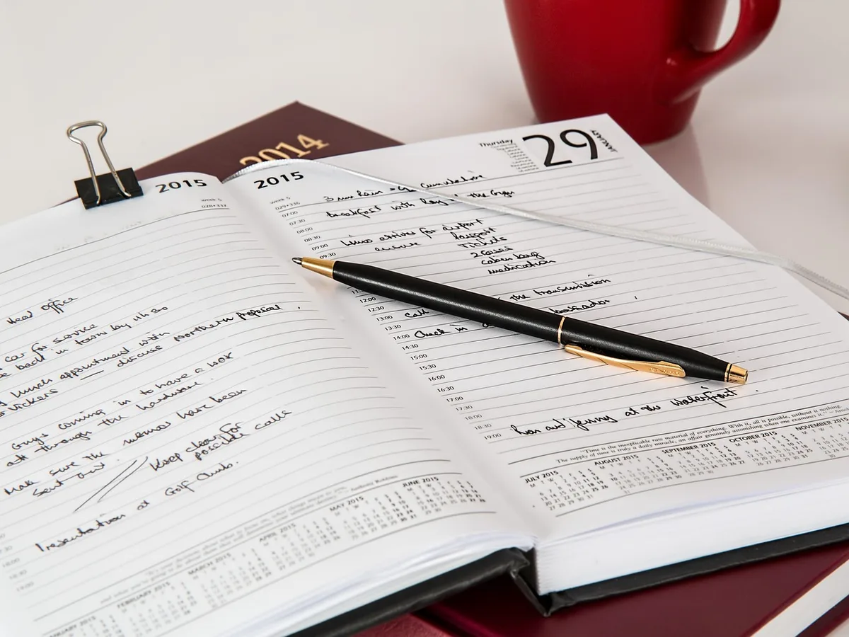 Carnet ouvert montrant un calendrier hebdomadaire et notes sur le format