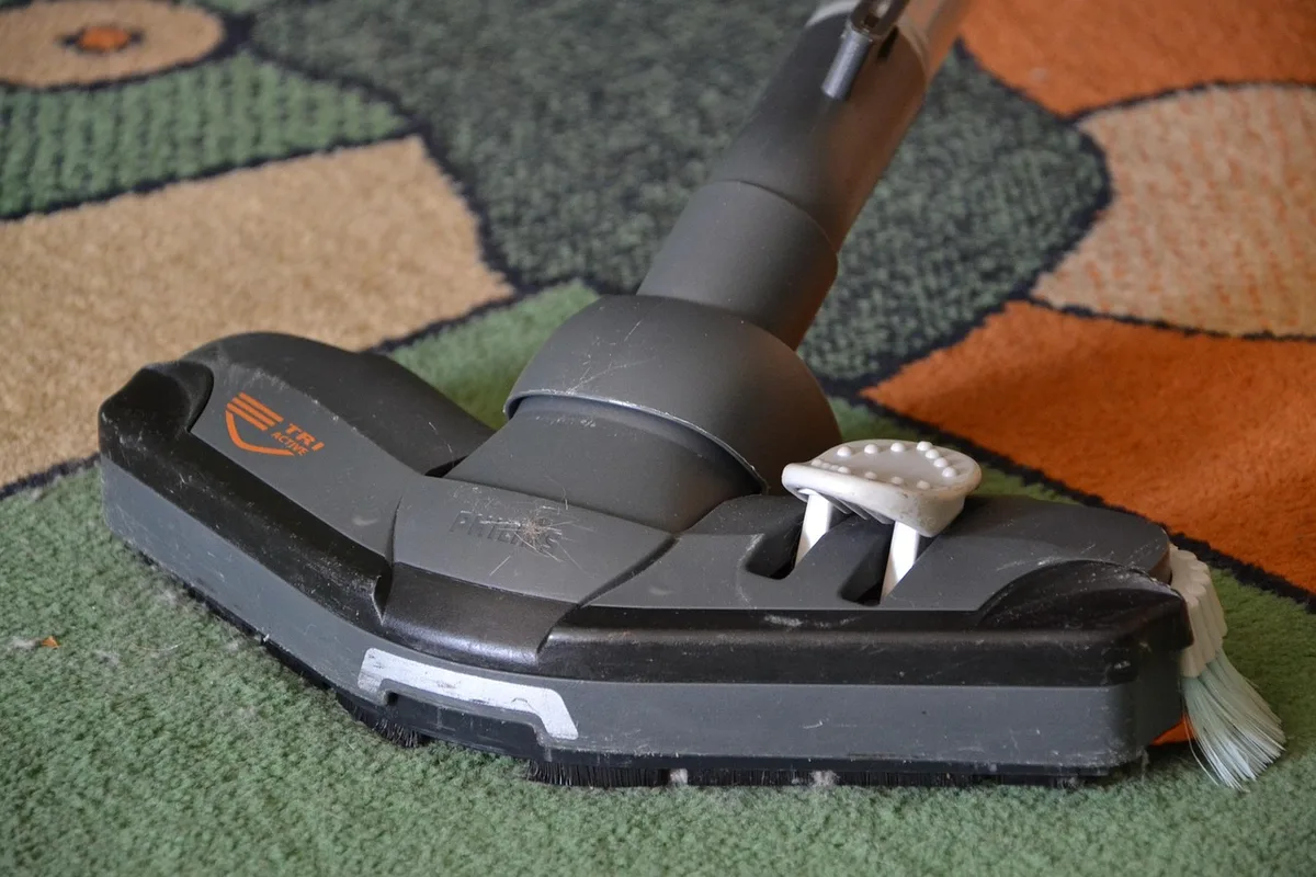 Aspirateur sur roulettes posé près d'un bassin, prêt à être déplacé